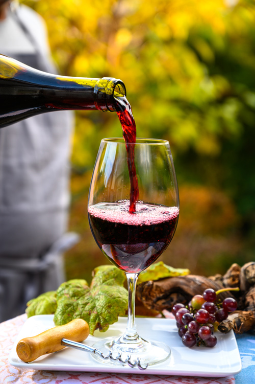 Rotwein wird in Glas eingeschenktWein